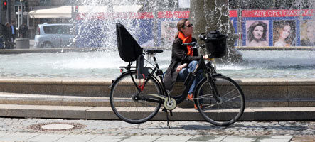 Fahrradfahrer macht Pause an Brunnen