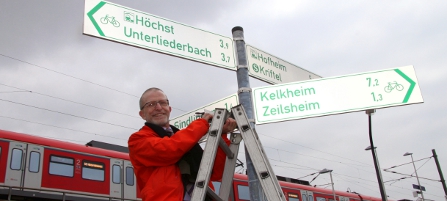 Verkehrsdezernent Majer montiert symbolisch einen Radwegweiser